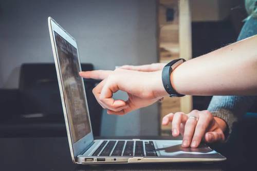 Estudiantes frente a una computadora, que representan las clases en línea de GMAT y GRE impartidas por el Brujo Method.
